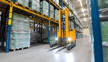 Worker operating a Jungheinrich sit-down moving mast reach truck